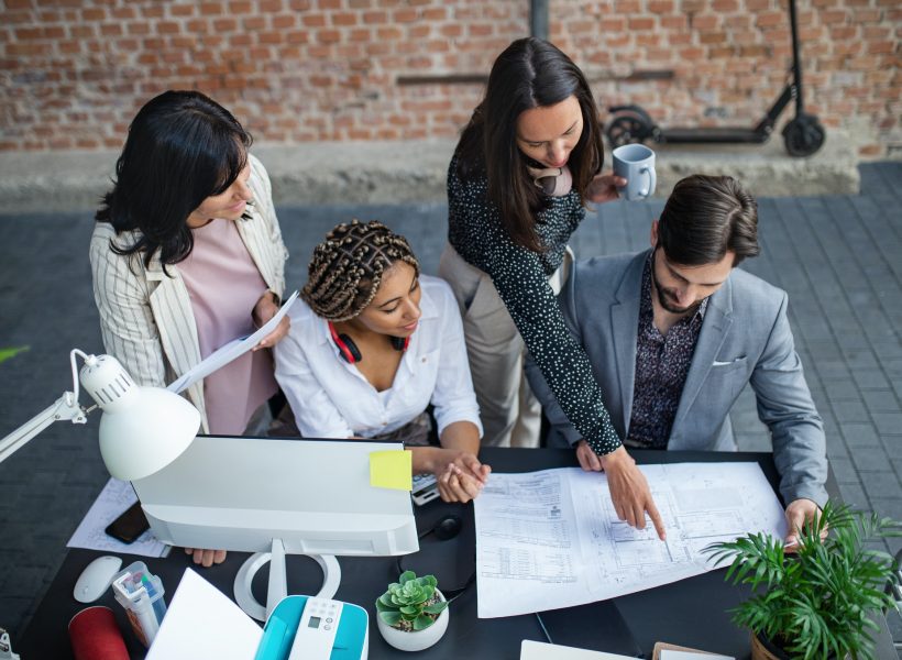 top-view-of-young-and-old-architects-sitting-and-working-at-desk-in-office-cooperation-concept.jpg